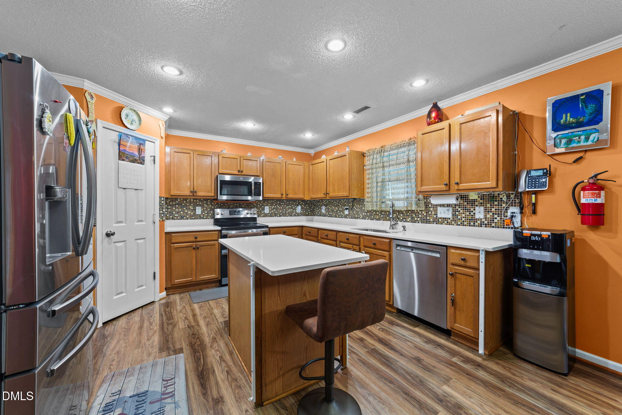 135 Oakton Ridge Place Garner, NC 27529 - Photo 8 of 40 a kitchen with stainless steel appliances granite countertop a refrigerator a sink dishwasher a stove and white countertops with wooden floor