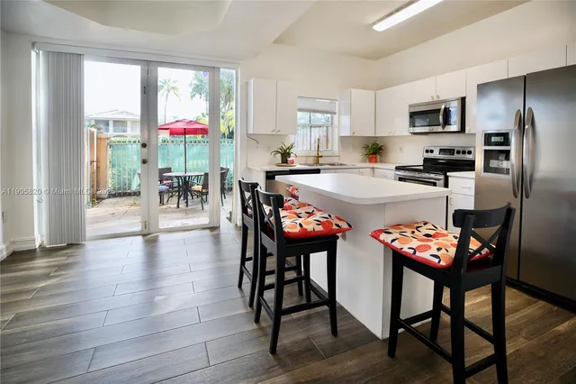 a kitchen with granite countertop stainless steel appliances and dining table
