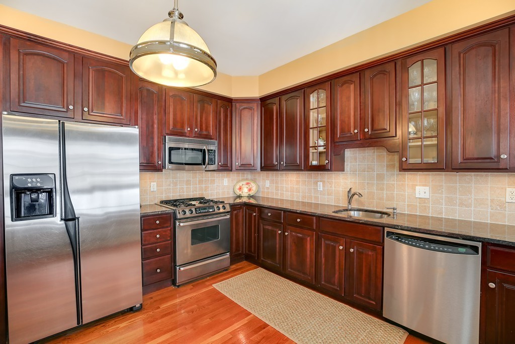 94 University Road, Unit 3 Brookline, MA 02446 - Photo 6 of 20 a kitchen with stainless steel appliances granite countertop a stove a sink dishwasher a refrigerator and cabinets with wooden floor