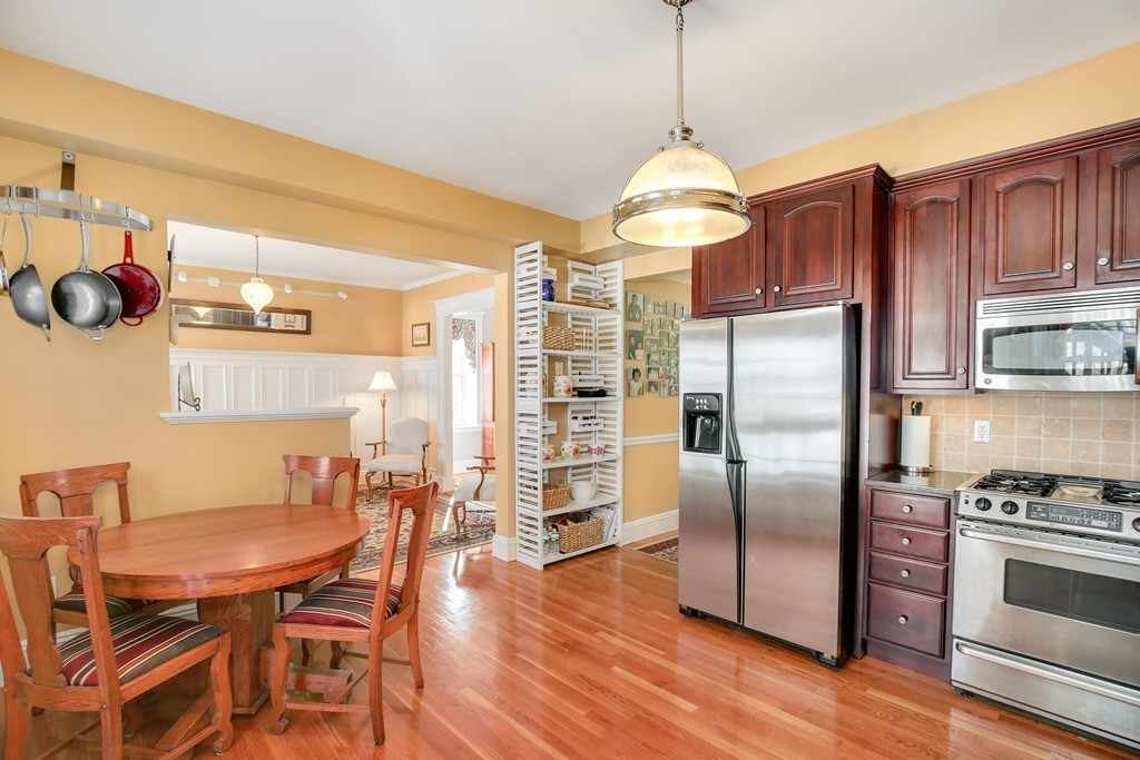 94 University Road, Unit 3 Brookline, MA 02446 - Photo 7 of 20 a kitchen with stainless steel appliances granite countertop a kitchen island hardwood floor and a view of living room