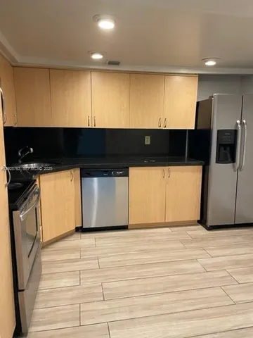 a kitchen with stainless steel appliances kitchen island granite countertop a stove a sink and a microwave