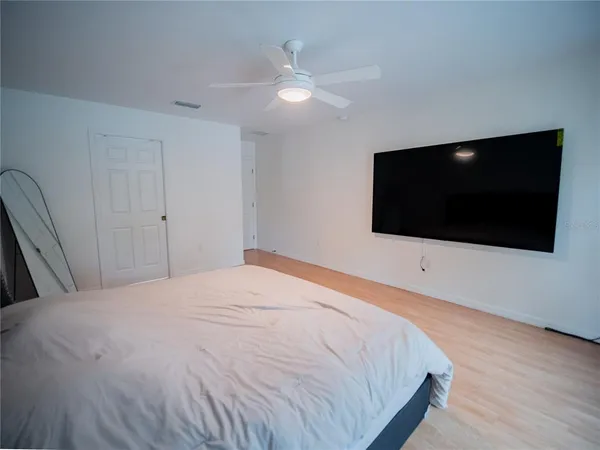 a bedroom with a bed and a flat screen tv