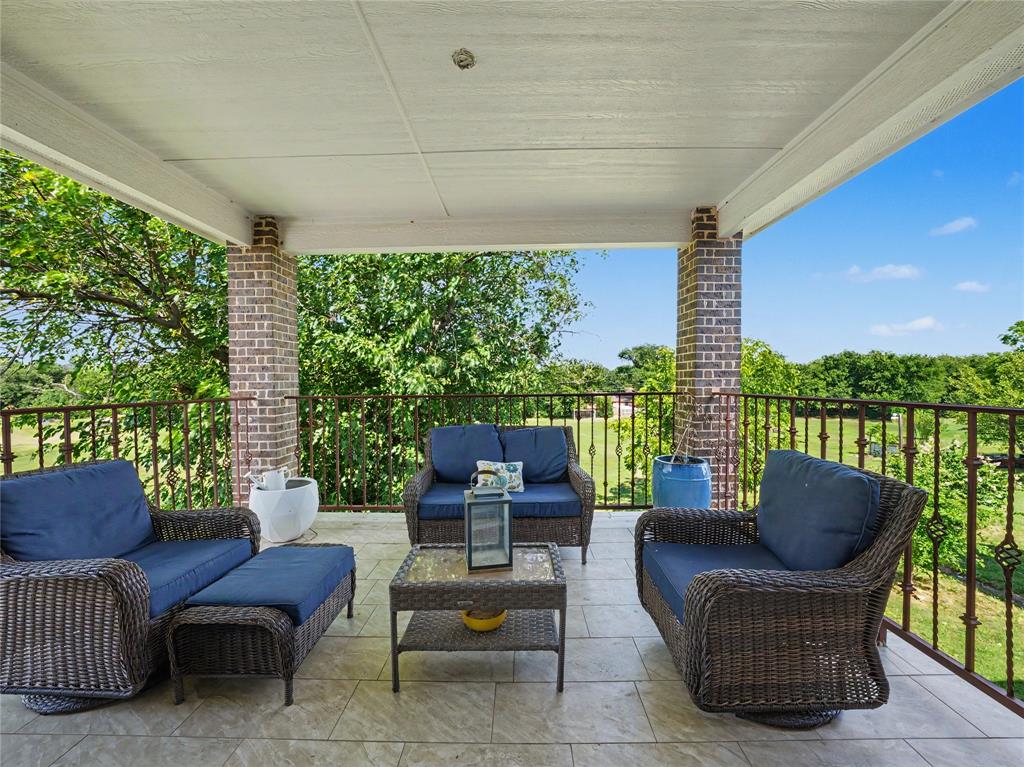 6701 Nauert Road Forest Hill, TX 76140 - Photo 31 of 40 Covered patio featuring brick support columns, a metal railing, and tile flooring