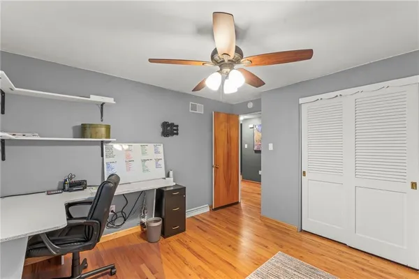 a view of a workspace with furniture and a window