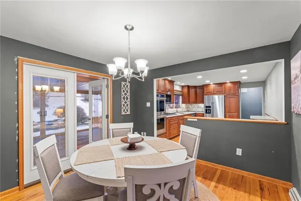 a view of a dining room with furniture a chandelier and wooden floor