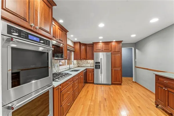 a kitchen with stainless steel appliances a refrigerator and a stove top oven