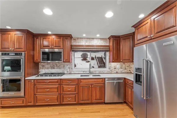 a kitchen with stainless steel appliances granite countertop a refrigerator and a stove top oven