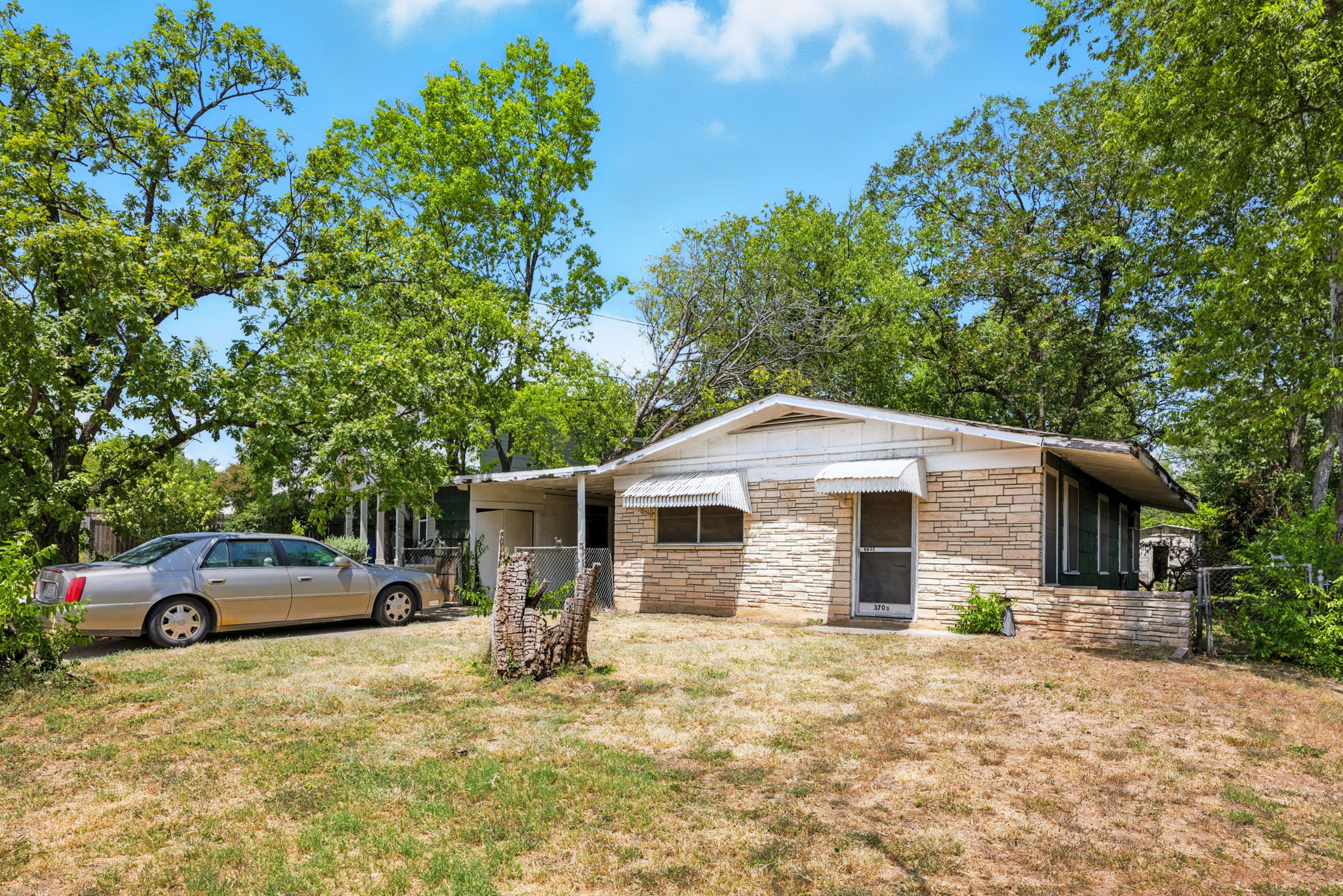 3709 Tower View Court Austin, TX 78723 - Photo 4 of 11 View of front facade featuring a front lawn, stone siding, and an attached carport