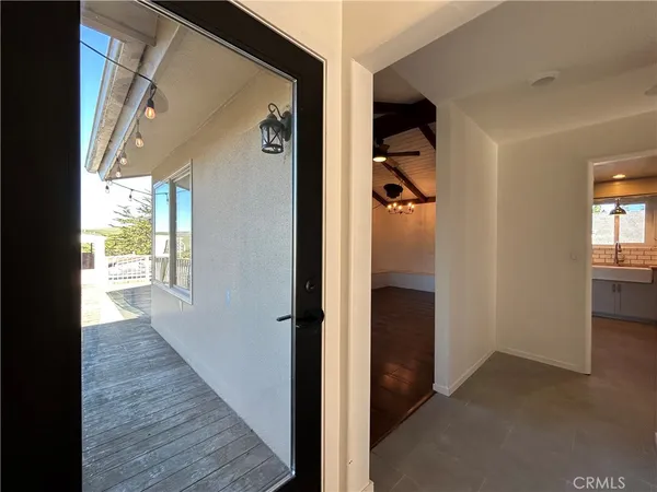 a view of a hallway with wooden floor and a living room