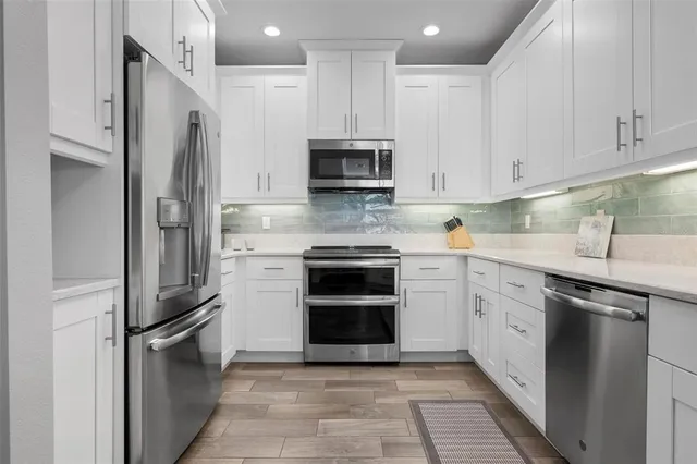 a kitchen with stainless steel appliances granite countertop a stove a refrigerator and a sink