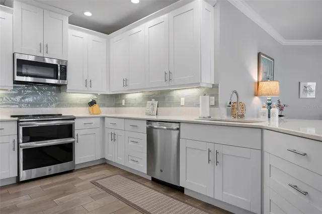 a kitchen with white cabinets and stainless steel appliances