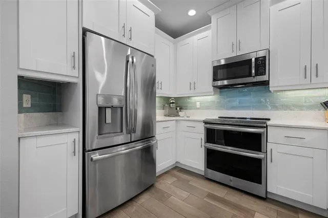 a kitchen with stainless steel appliances and white cabinets