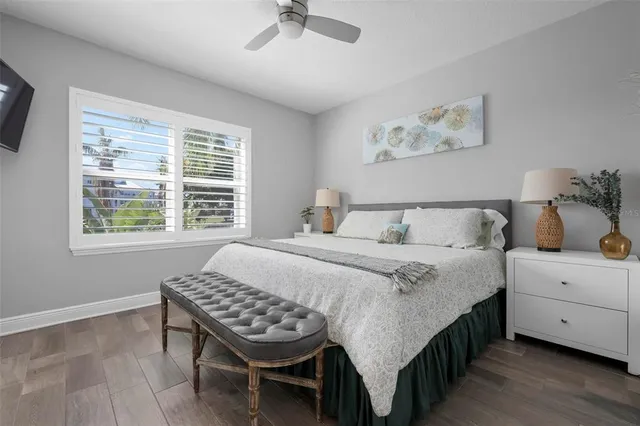 a bedroom with a bed a couch and a window with wooden floor