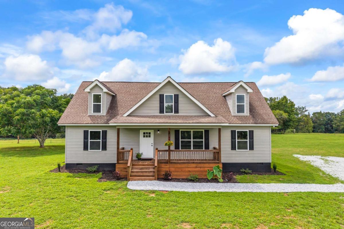 1718 Ed Bennett Road Nicholson, GA 30565 - Photo 11 of 71 a front view of a house with a yard table and chairs
