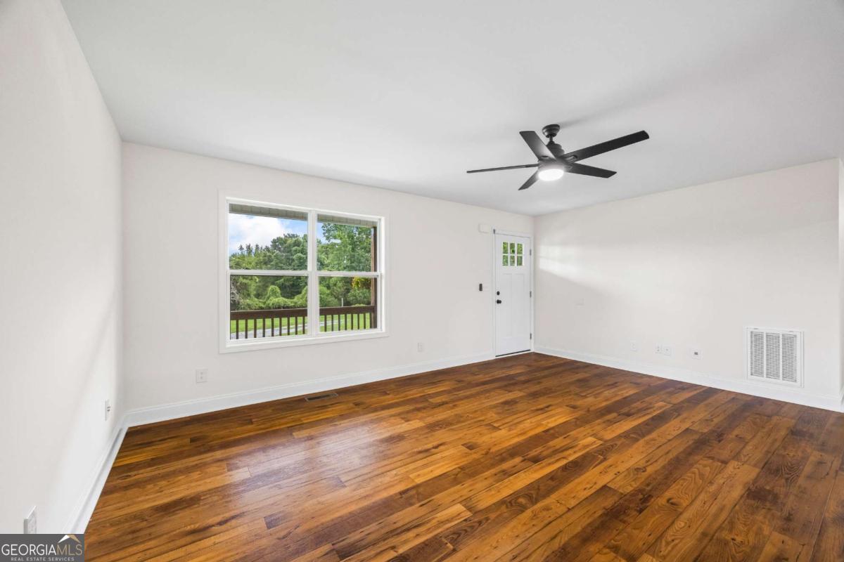 1718 Ed Bennett Road Nicholson, GA 30565 - Photo 21 of 71 a view of a big room with wooden floor and a window