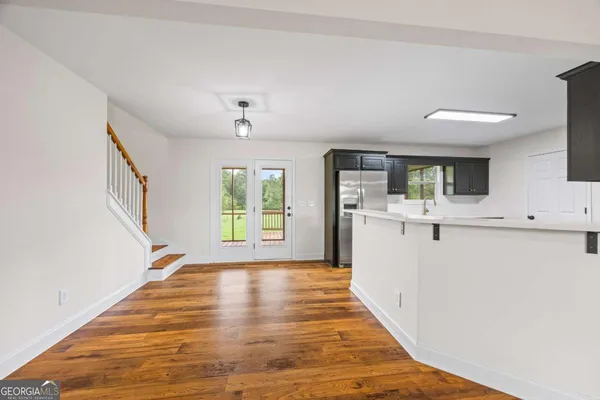 a kitchen with wooden floors and stainless steel appliances