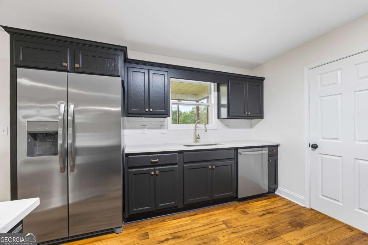 1718 Ed Bennett Road Nicholson, GA 30565 - Photo 30 of 70 a kitchen with stainless steel appliances granite countertop a refrigerator and a sink