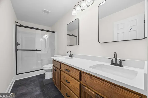 a bathroom with a sink a toilet and shower