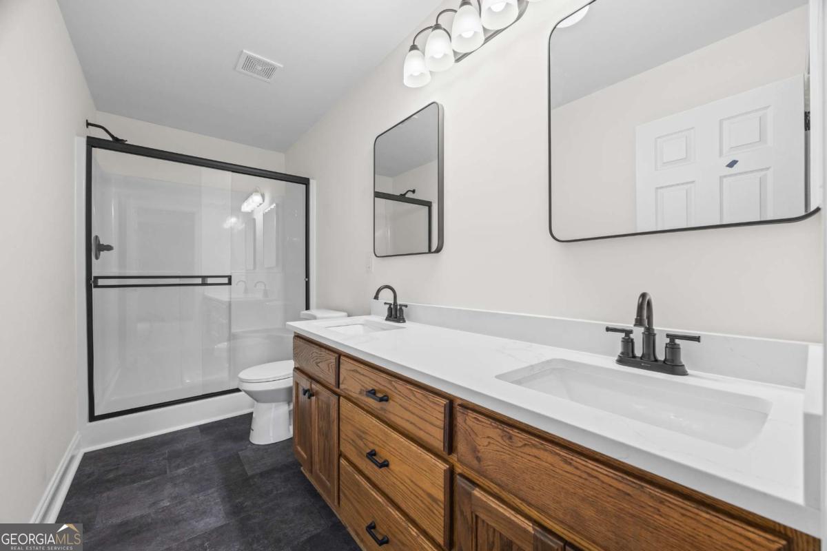 1718 Ed Bennett Road Nicholson, GA 30565 - Photo 37 of 71 a bathroom with a double vanity sink mirror and toilet