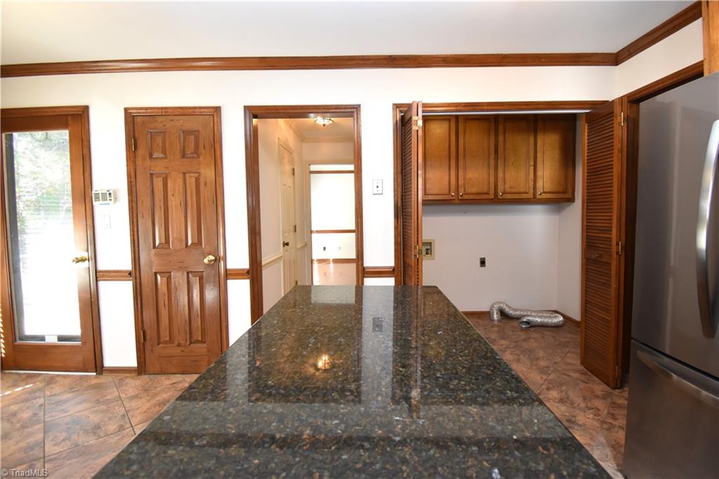 422 Wildwood Lane Graham, NC 27253 - Photo 7 of 22 From left to right we have access to the back patio. Storage. Hallway to the 1/2 bath and pantry, laundry area with hanging back and finally the door to the formal dinning room.