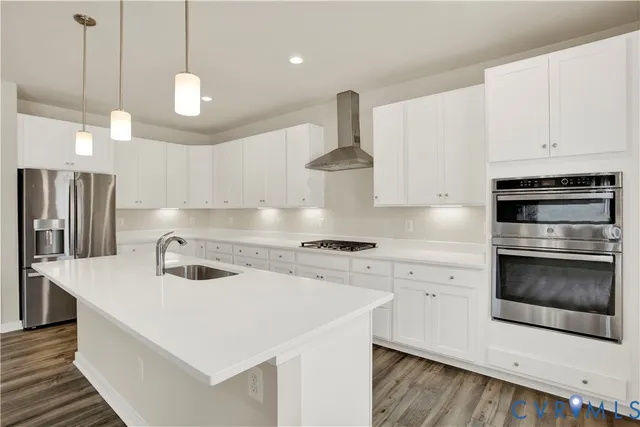 a kitchen with stainless steel appliances a stove a sink a oven a refrigerator and cabinets