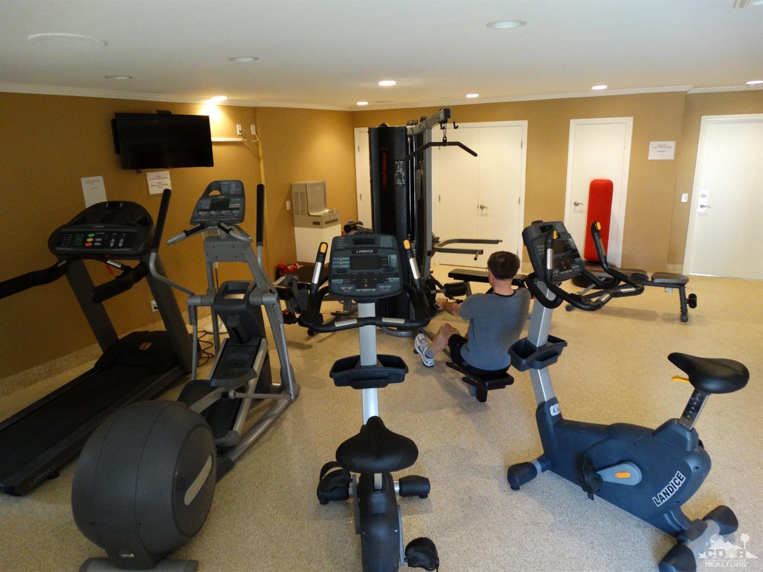 43376 Cook Street, Unit 127 Palm Desert, CA 92211 - Photo 14 of 31 a room with gym equipment and a large mirror
