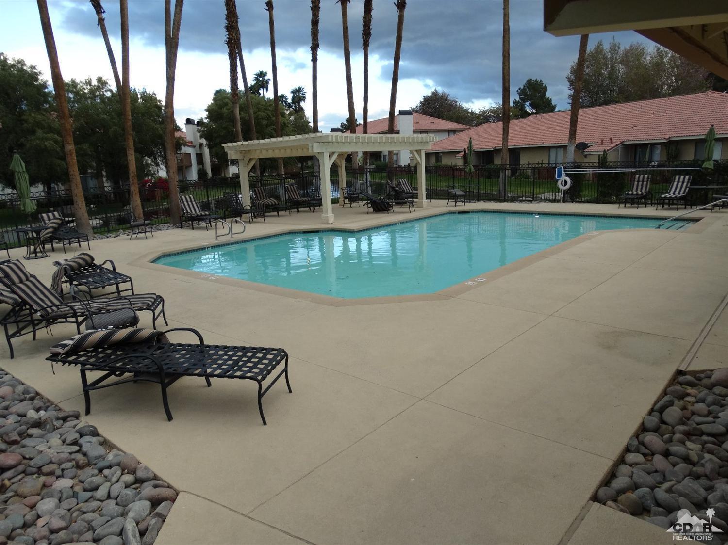 43376 Cook Street, Unit 127 Palm Desert, CA 92211 - Photo 31 of 31 a view of a swimming pool with outdoor seating and plants
