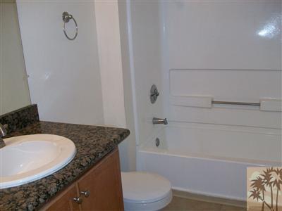 43376 Cook Street, Unit 127 Palm Desert, CA 92211 - Photo 5 of 31 a bathroom with a granite countertop bathtub sink vanity mirror and toilet