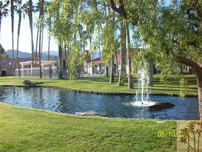 43376 Cook Street, Unit 127 Palm Desert, CA 92211 - Photo 9 of 31 a view of a lake with a house in the background