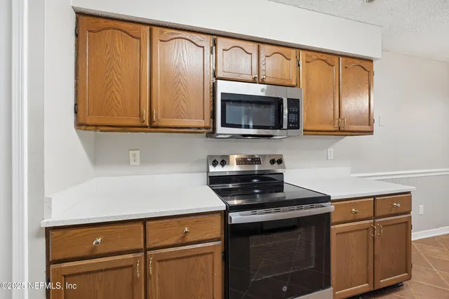 a kitchen with granite countertop cabinets stainless steel appliances and a counter space