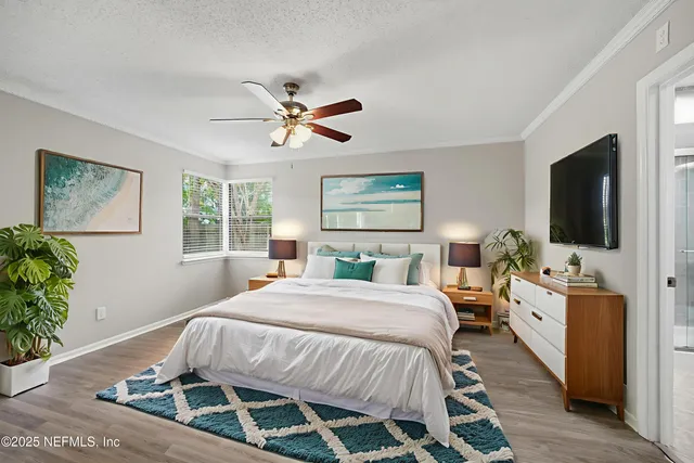 a bedroom with a bed a window and a flat screen television