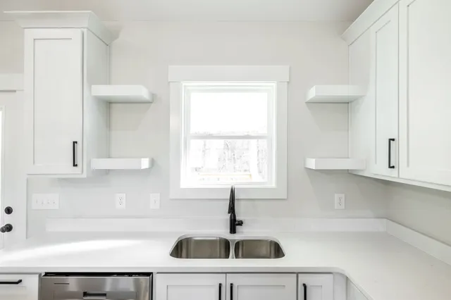a kitchen with a sink cabinets and window