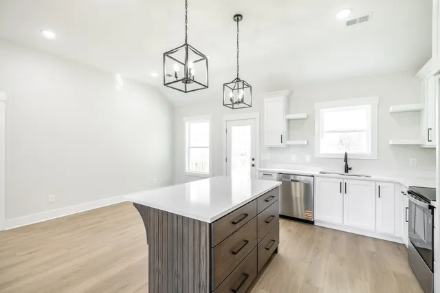 a kitchen with a sink chandelier and stove