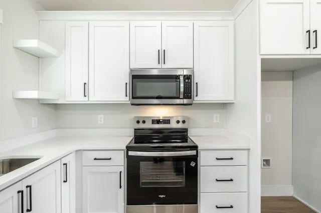 a kitchen with stainless steel appliances a stove a microwave and cabinets