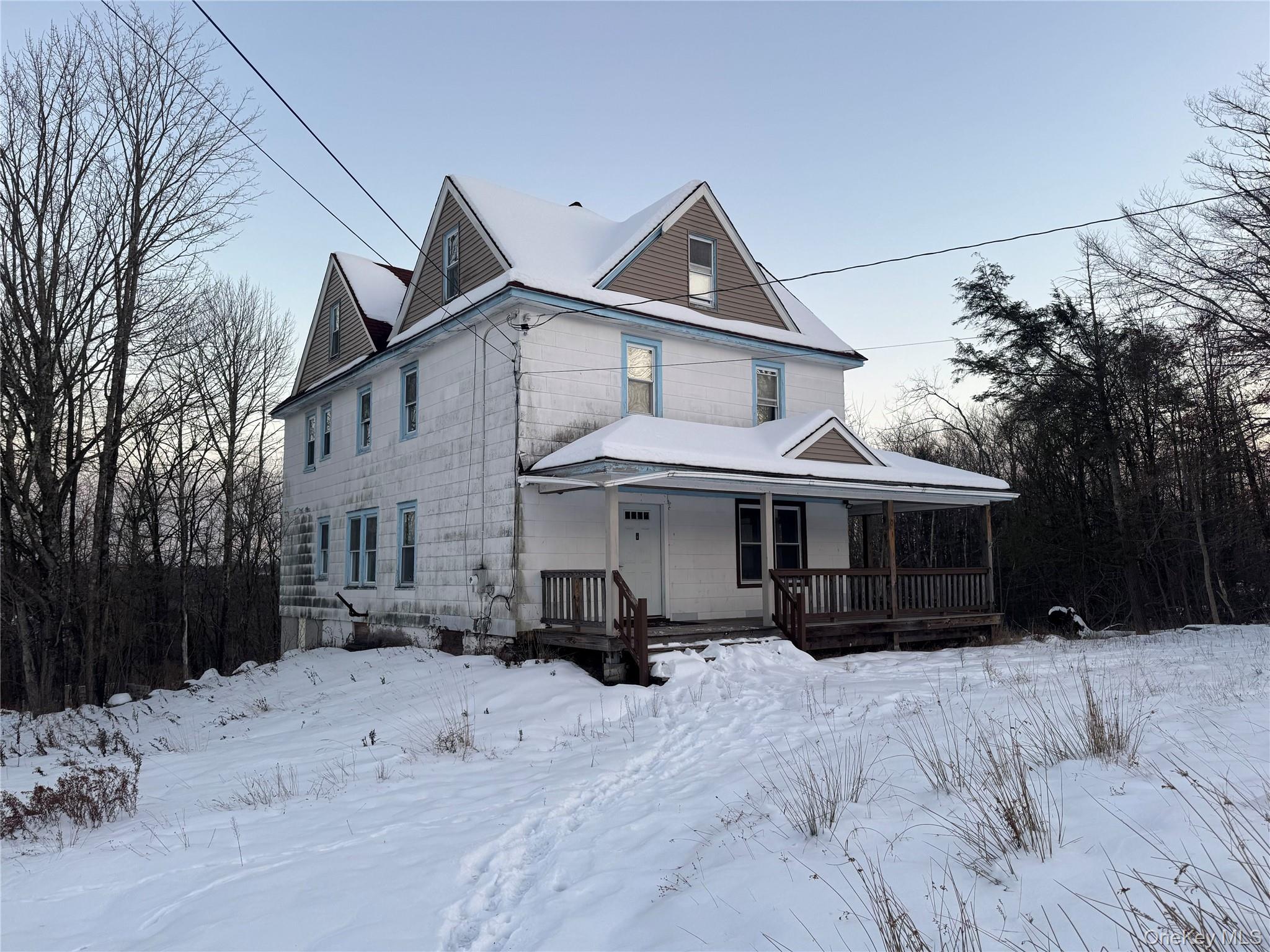 a view of a white house with a yard covered in snow