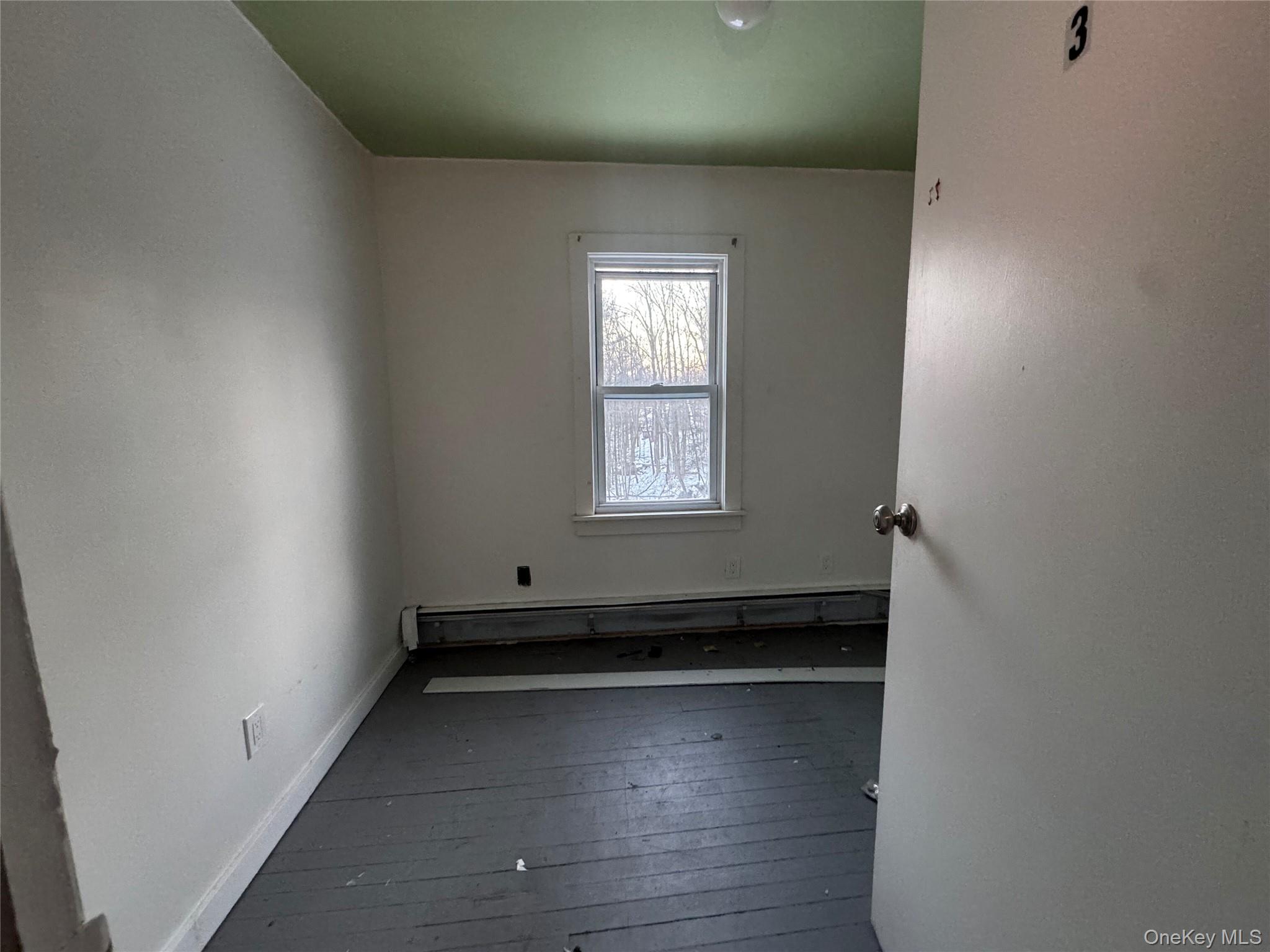 74 Cold Spring Road Liberty, NY 12754 - Photo 9 of 16 an empty room with wooden floor and windows