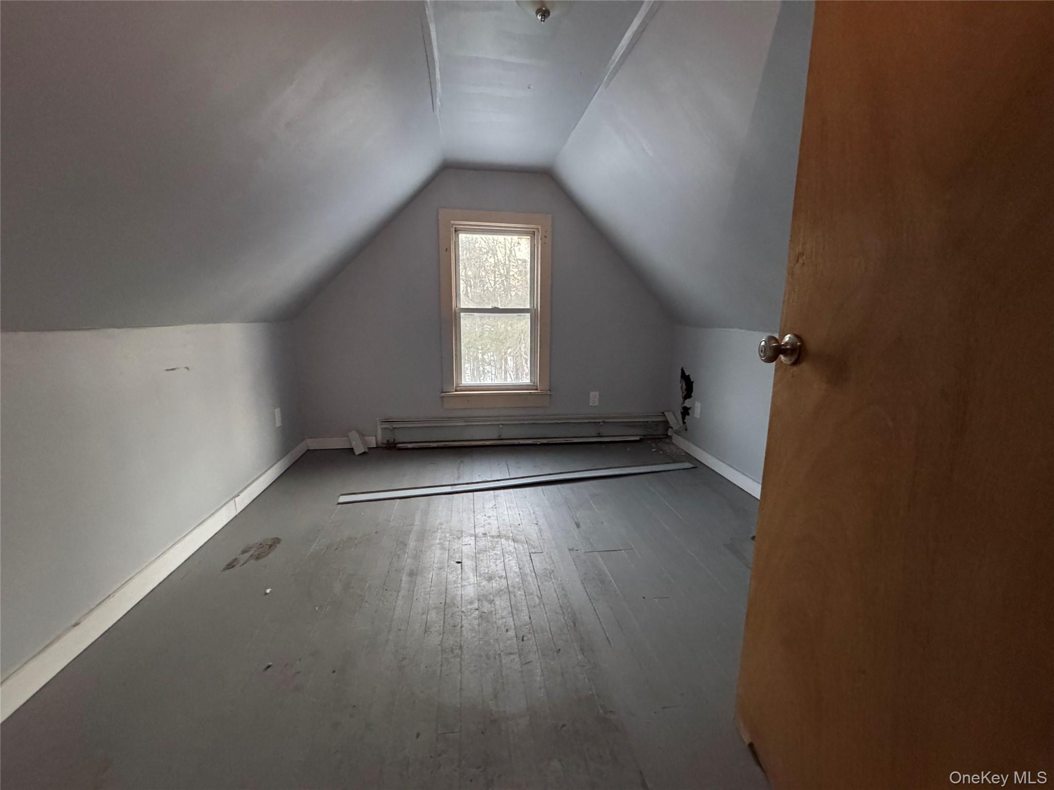 74 Cold Spring Road Liberty, NY 12754 - Photo 10 of 16 an empty room with wooden floor and windows