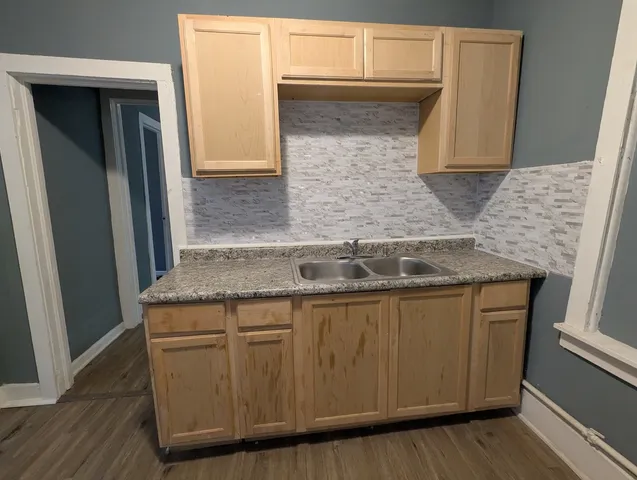 a kitchen with granite countertop wood cabinets and a sink