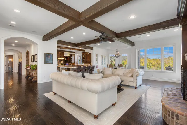 a view of a house with a big yard potted plants and large tree