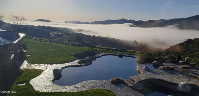 an aerial view of a house with a garden and lake view