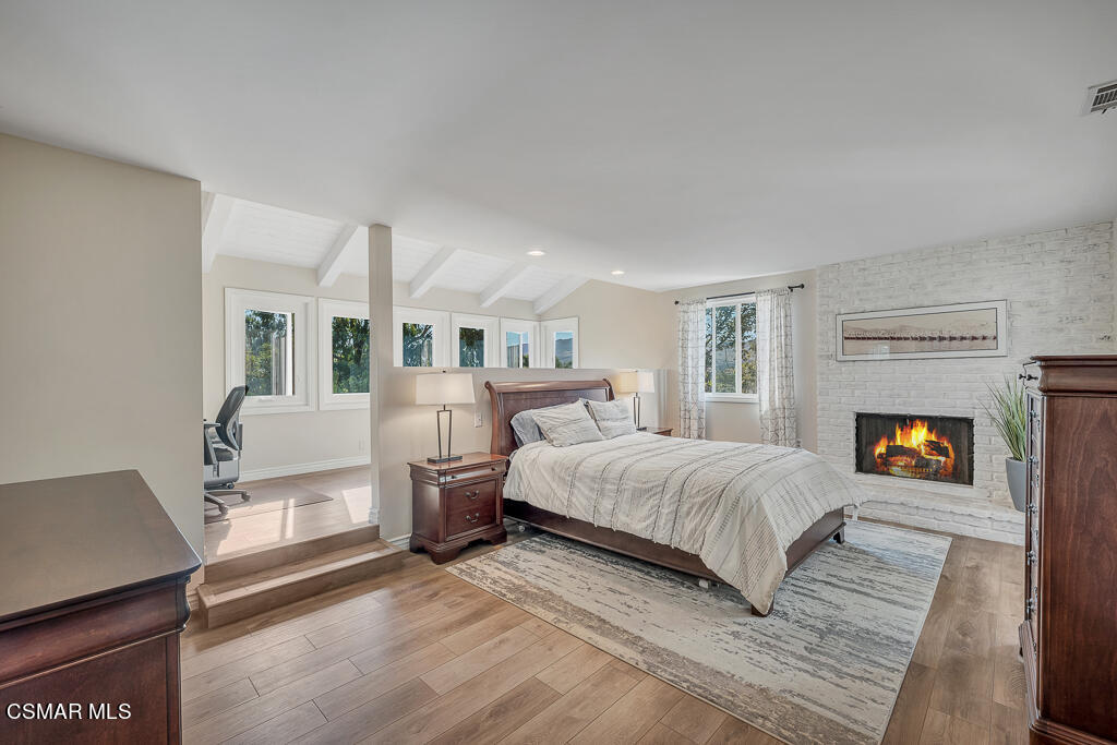 11780 Barranca Road Camarillo, CA 93012 - Photo 9 of 26 a spacious bedroom with a bed a fireplace and a table