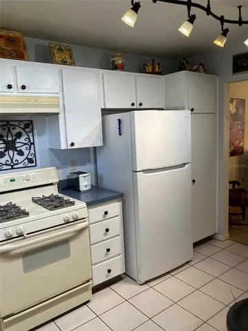 a white refrigerator freezer and a stove sitting inside of a kitchen