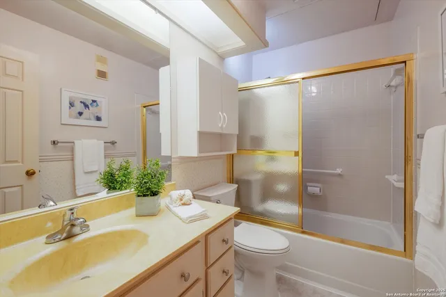 a bathroom with a sink mirror vanity and toilet