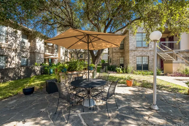 a view of a patio with table and chairs and potted plants