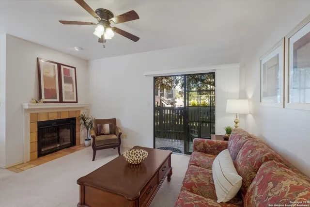 a living room with furniture a fireplace and a large window