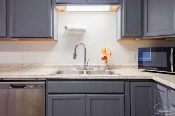a kitchen with granite countertop a sink and cabinets