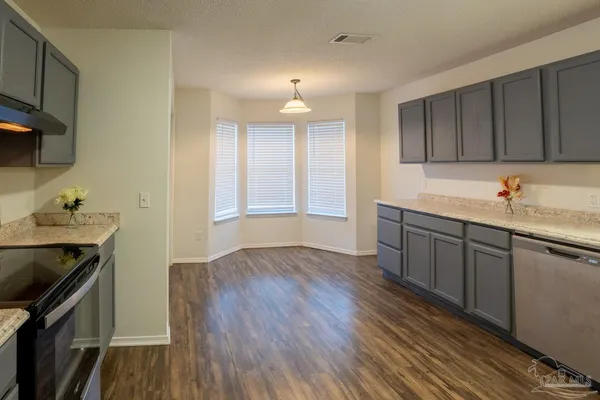 a kitchen with sink cabinets and wooden floor