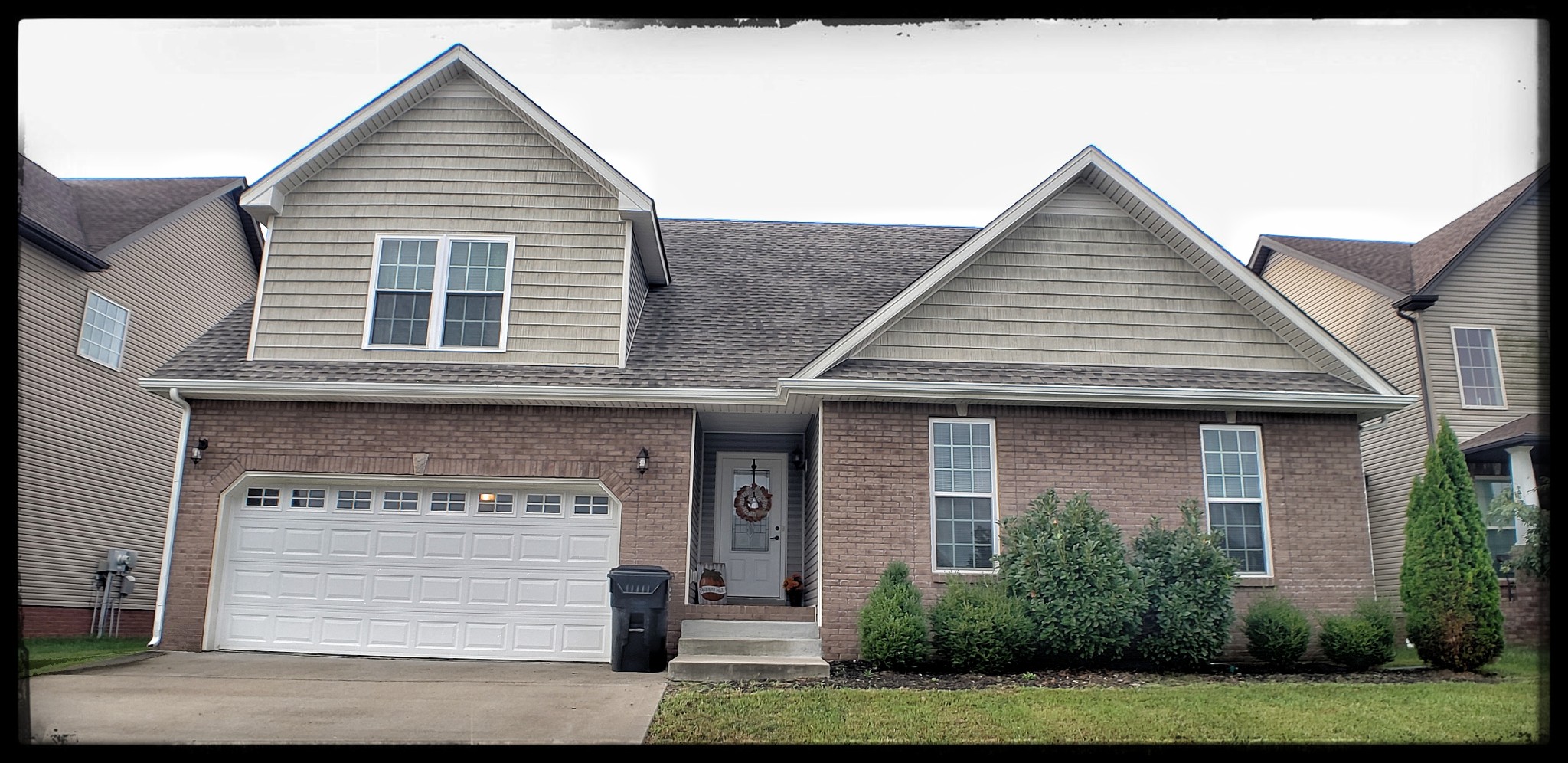 a front view of a house with a garden and garage