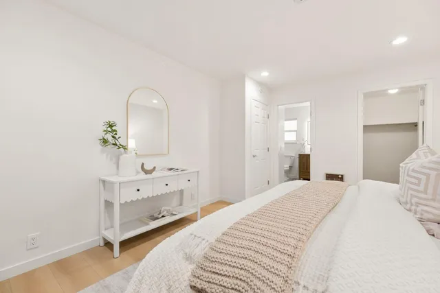 a spacious bedroom with a bed and a dresser