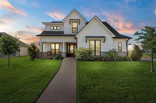 a front view of a house with a yard and potted plants
